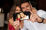 Couple Taking Selfie In Cafe Stock Photo