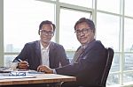 Couples Of Business Man Working On Office Working Table With Smiling Face Looking To Camera Stock Photo