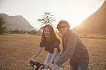 Couples Of Younger Asian Man And Woman Practice To Riding Bicycle In Natural Field Relaxing Emotion Stock Photo