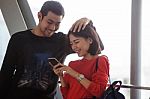 Couples Of Younger Asian Man And Woman Relaxing With Happy Face Reading Text On Smart Phone Use For People And Modern Lifestyle Stock Photo