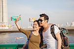 Couples Of Younger Man And Woman Take A Selfie Photograph By Smart Phone On Traveling Location Stock Photo