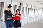 Couples Of Younger Traveling Man And Woman Looking To Traveler Guide Book On Location Stock Photo