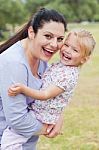 Curious Mother Carrying Her Daughter With Big Smile Stock Photo