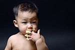 Cute Asian Baby Eating Cake With His Hand Stock Photo