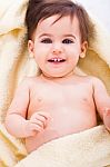Cute Baby Smiling Covered In Yellow Towel Stock Photo