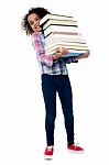 Cute Cheerful Child Carrying Stack Of Books Stock Photo