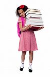 Cute Little Schoolgirl Carrying Stack Of Books Stock Photo