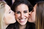 Cute Smiling Girl Kissed On The Cheeks By Her Friends Stock Photo