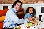 Daughter Enjoying Meal With His Father Stock Photo