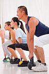 Diverse Group Practicing Kettlebell Exercise In Crossfit Gym Stock Photo