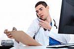 Doctor Convey His Notes To Others Over Phone Stock Photo