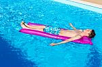 Dutch Teenage Boy Lying  On Air Mattress In Swimming Pool Stock Photo
