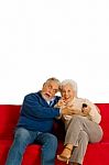 Elderly Couple With Remote Control Stock Photo