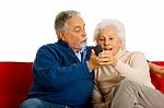 Elderly Couple With Remote Control Stock Photo