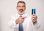 Elderly Man Focusing On Debit Card Stock Photo