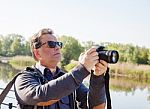 Elderly Man Photographing River Stock Photo