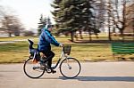 Elderly Man Wearing Glasses Riding A Bicycle Fast Stock Photo