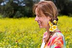 European Woman Wearing Braid With Yellow Flowers Near Coleseed F Stock Photo