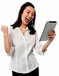 Excited Businesswoman Holding Touch Pad Stock Photo