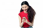 Excited Pretty Girl Sending A Text Message Stock Photo