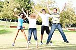 Family Jumping High In The Air On A Green Meadow Stock Photo