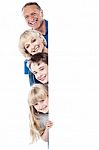 Family Of Four Behind Blank Whiteboard Stock Photo