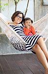 Family Relaxing Time Mother And Young Kid On White Clothes Cradl Stock Photo