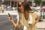 Fashionable Young Brunette Laughs Into Phone, Urban Background Stock Photo