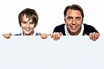 Father And Son Posing Behind Big Blank Banner Ad Stock Photo