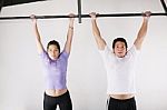 Female And Male Taking Pull Ups Stock Photo
