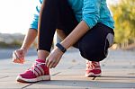 Female Athlete Tying Laces For Jogging Stock Photo