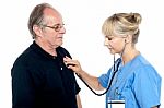 Female Doctor Examining An Elderly Man Stock Photo