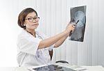 Female Doctor Pointing To X-ray Film Of Head Gull Stock Photo