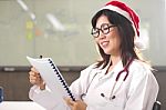 Female Doctor Reading Report Stock Photo