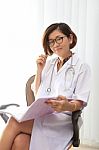 Female Doctor Sitting In Her Working Room With Smiling Face Stock Photo