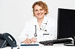 Female Doctor Writing On Clipboard Stock Photo