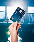 Female  Hand Holding Credit Card Against Business Office Backgro Stock Photo