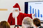 Female Santa Claus Presenting In Business Meeting Stock Photo