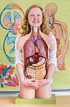 Female Student Embracing Model Of Human Body With Organs Stock Photo