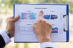 Finger Of Business Man Pointing To The Paper Report Stock Photo