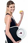 Fit Girl Holding Fruit And Weighing Scale Stock Photo