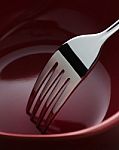 Fork In Dark Red Ceramic Dish Stock Photo