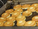 Freshly Made Donuts In The Fryer Stock Photo