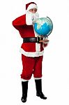 Full Length Portrait Of Santa Holding Globe Stock Photo