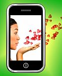 Girl Blowing Hearts From Mobile Stock Photo