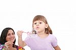 Girl Blowing Soap Bubbles With Mom Stock Photo