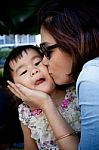 Girl Children And Mom Kissing On Cheek With Lovely Face Stock Photo