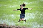 Girl Jumping In Paddy Field Stock Photo