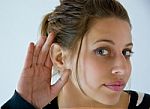 Girl Listens With Hand At Ear Stock Photo