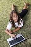 Girl Lying On Grass With Laptop Stock Photo